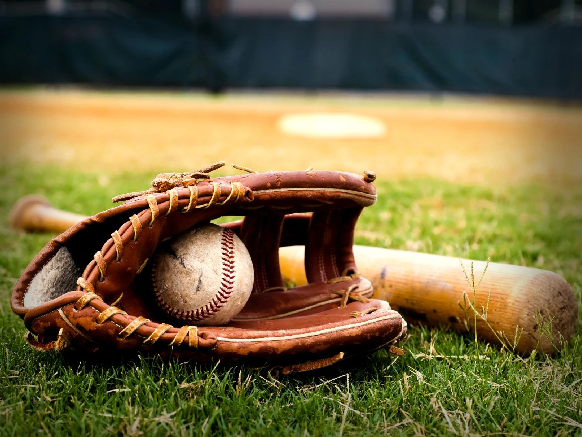 Bateador de béisbol golpea la bola que llega bajo los focos del estadio.
