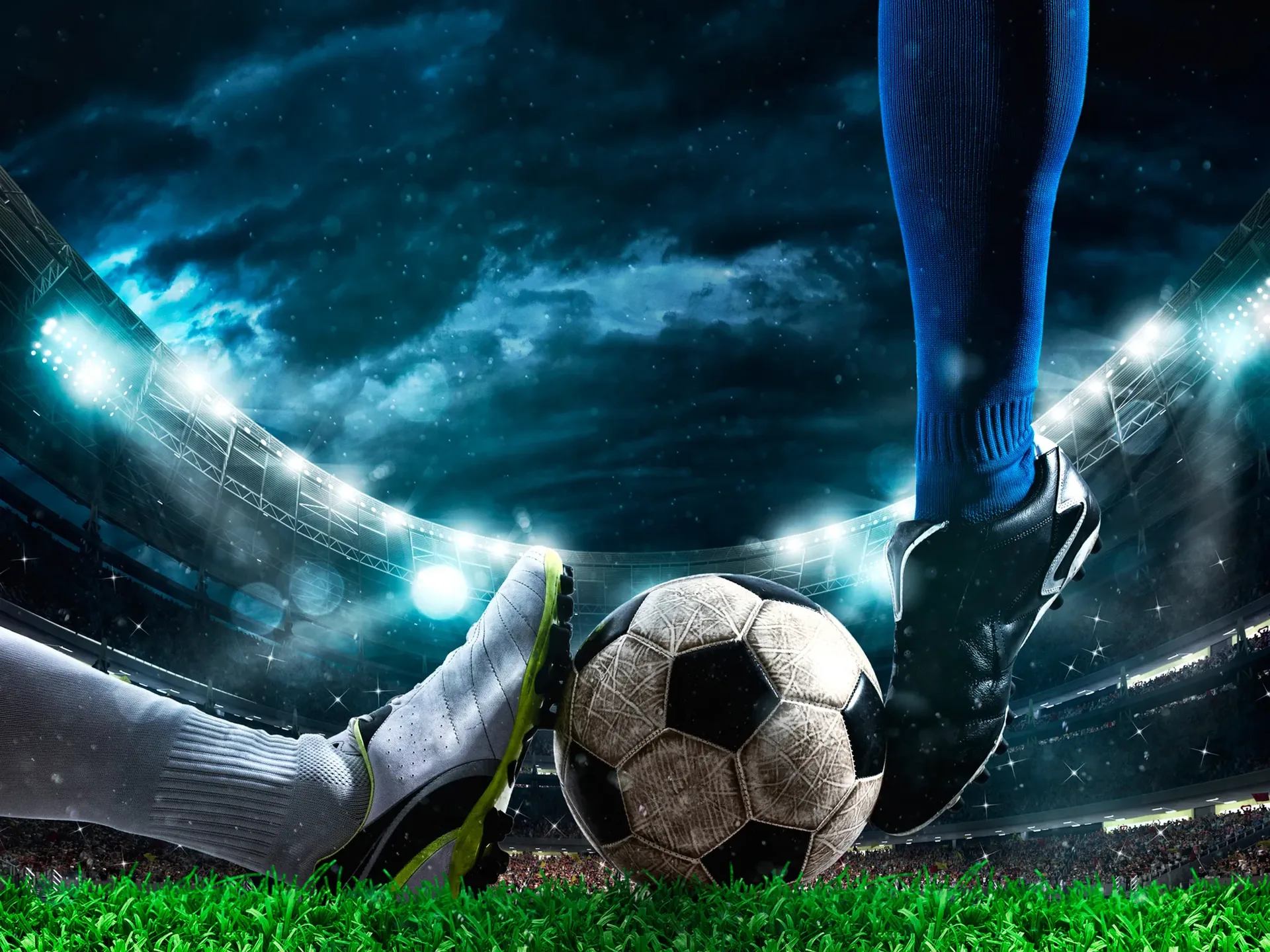 Futbolista golpea el balón en pleno partido sobre el césped iluminado.